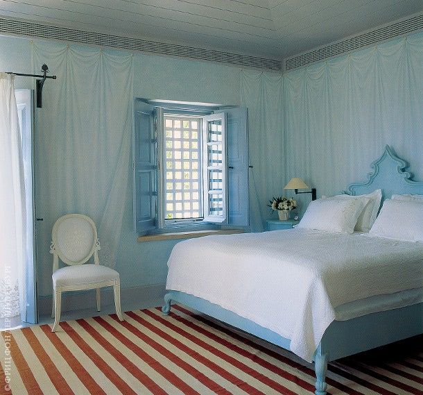 На стенах главной спальни — “обманка” изображающая занавеси. Кровать и стул по дизайну ­Стефанидиса.