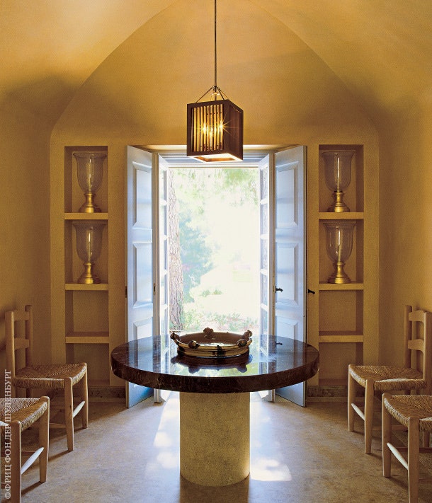 Над круглым мраморным столом в комнате для завтраков висит лампа Mustique по дизайну Стефанидиса.