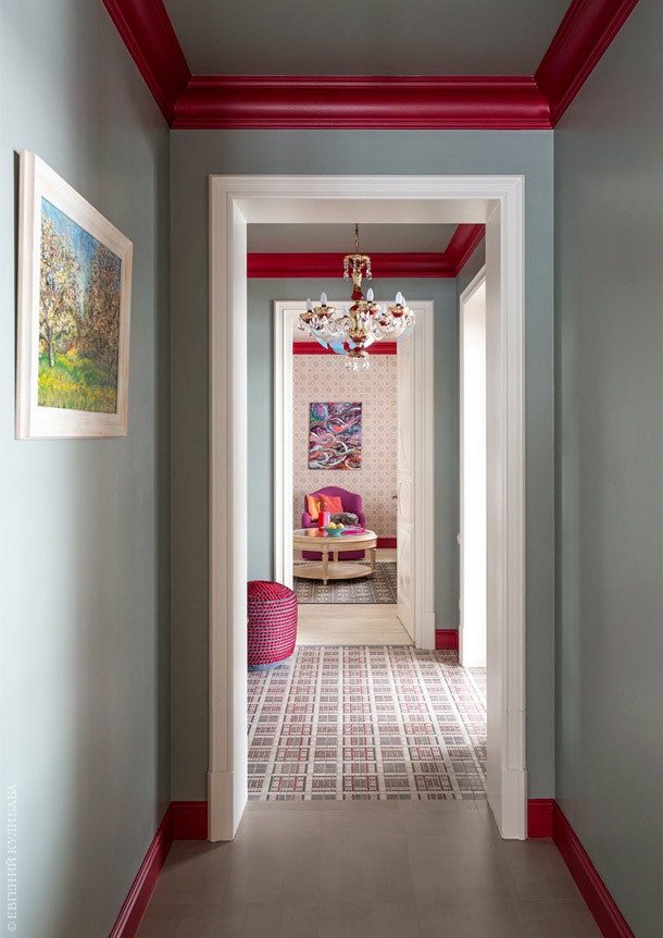Фоном коридора ведущего из холла в гостиную сделан практичный серый цвет. Красные карнизы и плинтуса — один из...