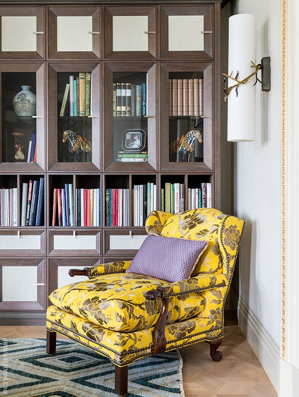 Фасады книжного шкафа обтянуты кожей имитирующей кожу страуса. Кресло и ковер сделаны на заказ. Бра Herv van der Straeten.