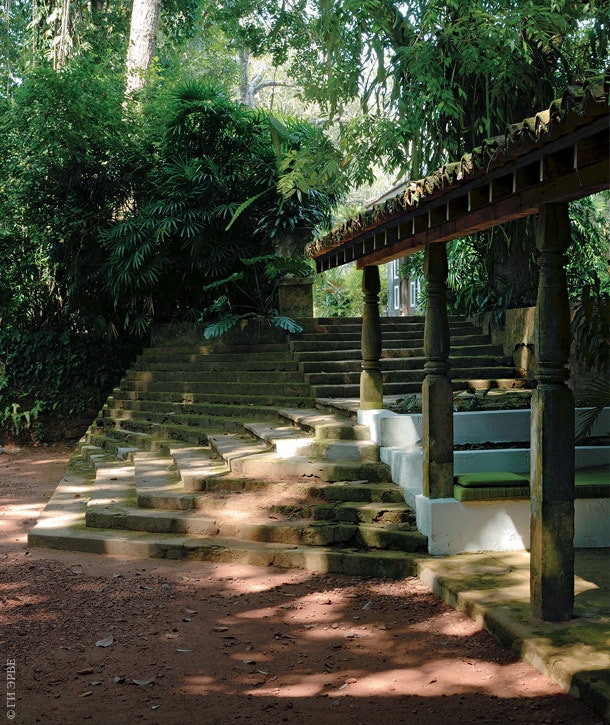 Лестница при входе в усадьбу заставляет вспомнить архитектуру буддийских храмов. Под навесом из тика устроено сиденье.