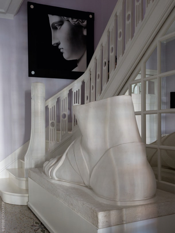 Перила лестницы выкрашены в белый цвет. Гигантская “римская” ступня сделана скульптором Адриано де Анджелисом из...