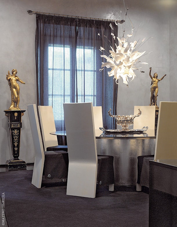 Столовая. Гранитный стол с основанием обшитым серебром  светильник Porca Miseria по дизайну Инго Маурера стулья Armani Casa.