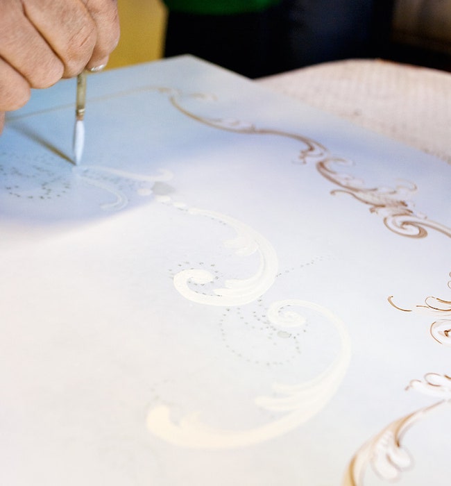 С кальки рисунок на поверхность переносят с помощью подкрашенного мыльного раствора а роспись по контуру выполняют вручную.