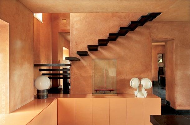 Под лестницей на второй этаж стоят настольные лампы Mezzoracolo Artemide и Ruspa Martinelli Luce обе дизайна Гаэ Ауленти.