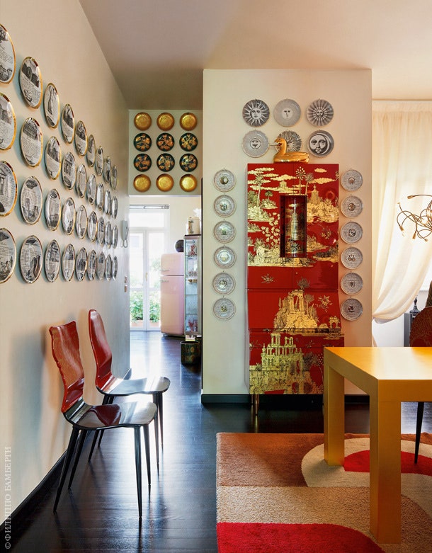 Зона гостиной. На стенах — впечатляющая коллекция тарелок по дизайну Пьеро Форназетти. Покрытый золотом стол сделан на...