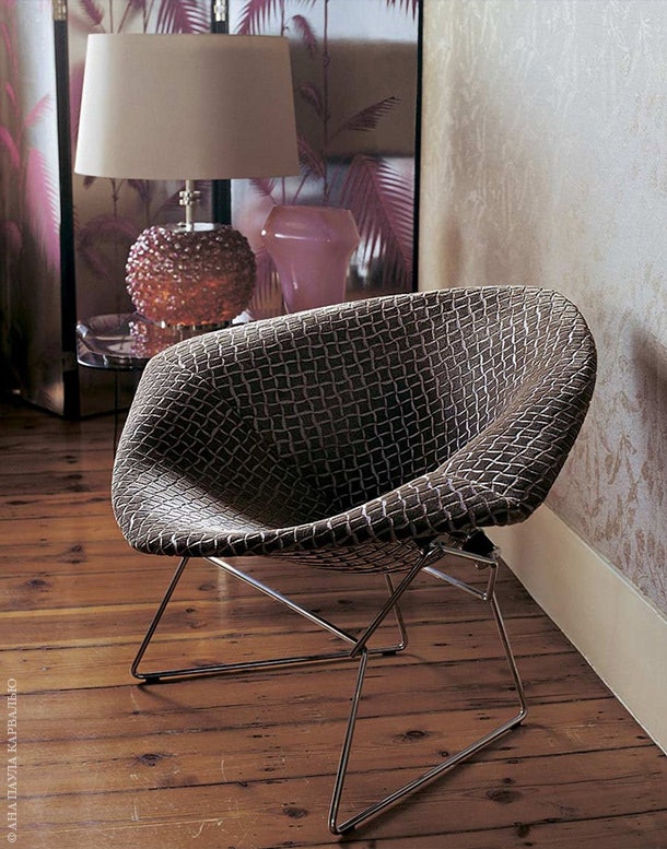 В гостиной — кресло дизайна Гарри Бертойи 1952 года. За ним — деревянная ширма покрытая черным лаком и оклеенная обоями...