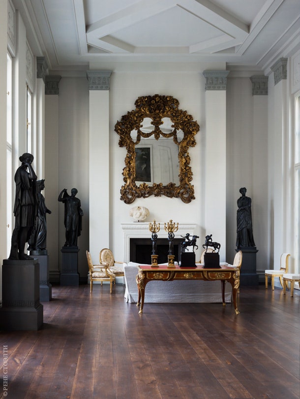 Над камином в главной гостиной — итальянское барочное зеркало. На письменном столе в стиле Людовика XV — статуэтки...