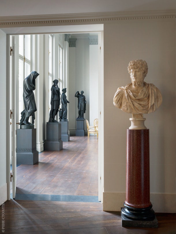 Вход в главную гостиную украшенную неоклассическими скульптурами из чугуна. На переднем плане бюст Луция Вера .