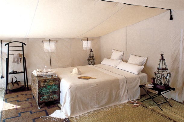 Интерьер в палатке — сочетание походной мебели и традиционных берберских вещей.