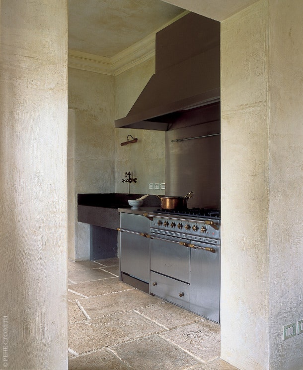 Кухня. Раковина в мойке сделана из черного гранита а пол покрыт плитами из песчаника.