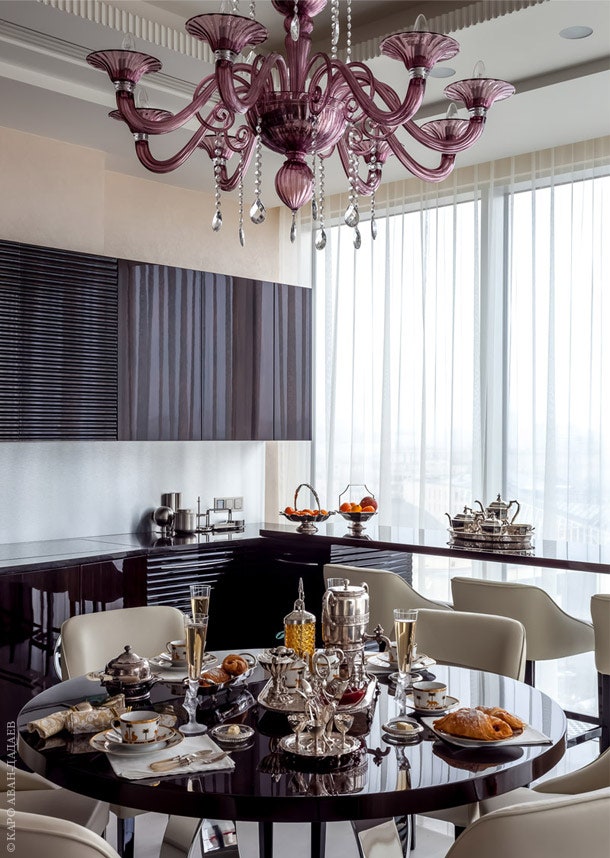 Лакированные поверхности кухонного гарнитура Francesco Molon и стола создают яркий контраст со светлым фоном стен и пола.