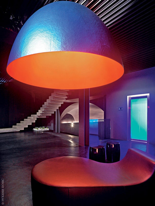 Пространство подвального этажа подсвечено синими лампами а светильник XXL Dome Ingo Maurer выполняет декоративную функцию.