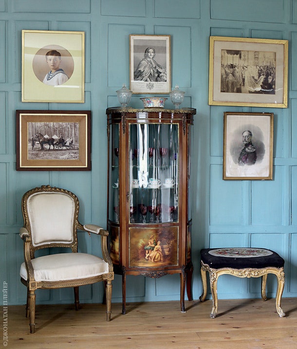 Вокруг витрины в гостиной — семейные портреты. Среди них гравюра с изображением церемонии коронации Николая II.