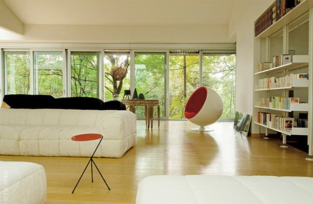 Огромные окна гостиной выходят на юг. Кресло Ball по дизайну Эро Аарнио диван по дизайну Чини Боэри. На итальянском...