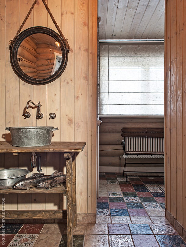 К ванной комнате на первом этаже примыкает сауна. Пол выложен изразцами. Раковина сделана из старого медного таза...