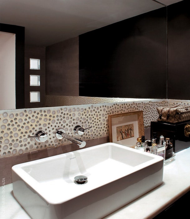 Стены в ванной украшены мозаикой из гальки.