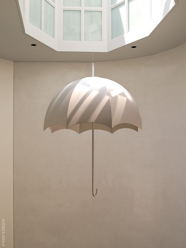 Скульптура в виде белого зонтика под фонарем на четвертом уровне квартиры.