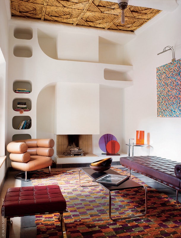 У камина в гостиной — кресло и столик по дизайну Эйлин Грей. Табурет и кушетка Barcelona по дизайну Людвига Мис ван дер...