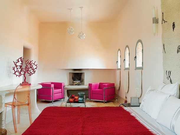 Кровать в “розовой спальне” застелена покрывалом из козьей шерсти. Пластиковый стул по дизайну Филиппа Старка Kartell....