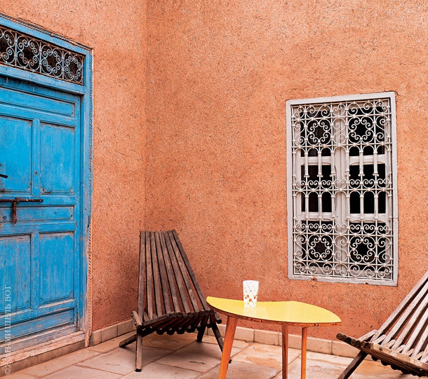 Один из внутренних двориков. Деревянные кресла и низкий желтый столик 1950х годов были найдены на рынке в Марракеше.