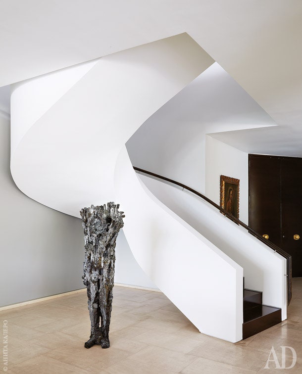 У подножия лестницы ведущей из прихожей на второй этаж стоит скульптура Мишель Ока Донер.