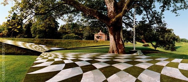 Терраса “черных дыр” шахматные квадраты пространствавремени сделаны из алюминия и дерна. На заднем плане — садовый...