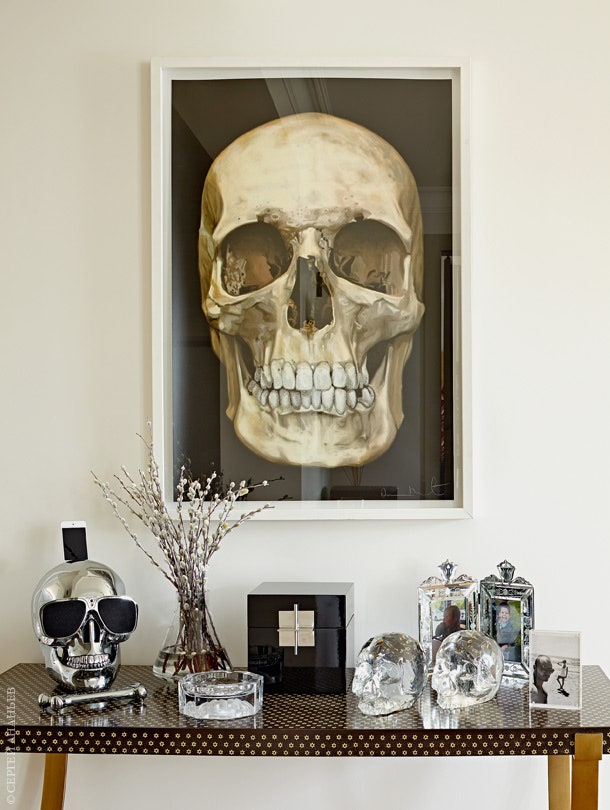 Литография Дэмиена Херста и коллекция черепов из различных материалов на консоли выдают пристрастия хозяина квартиры. В...