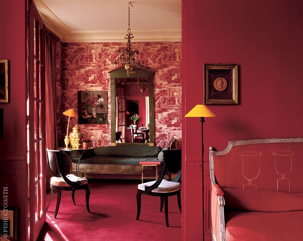 Вид из гостиной в столовую. Стены комнаты покрыты красными обоями с изображением гравюр начала XIX века на античные...