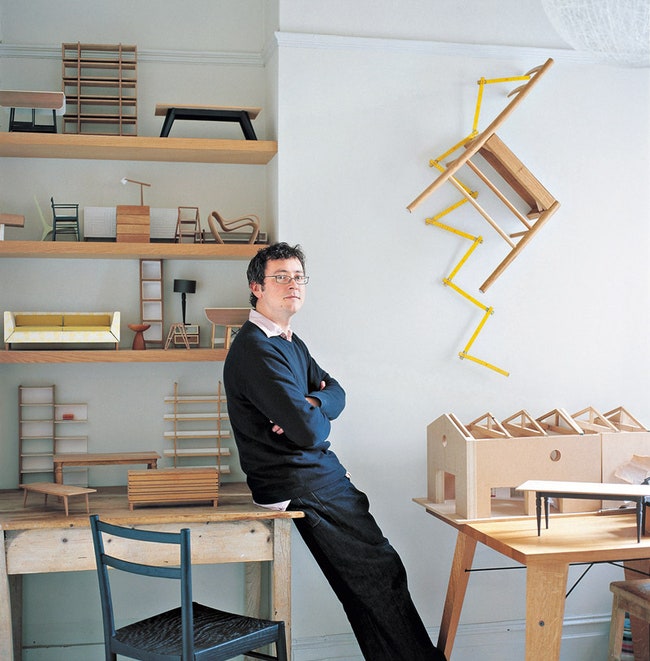 Рассел Пинч у себя дома в окружении миниатюрных моделей мебели.