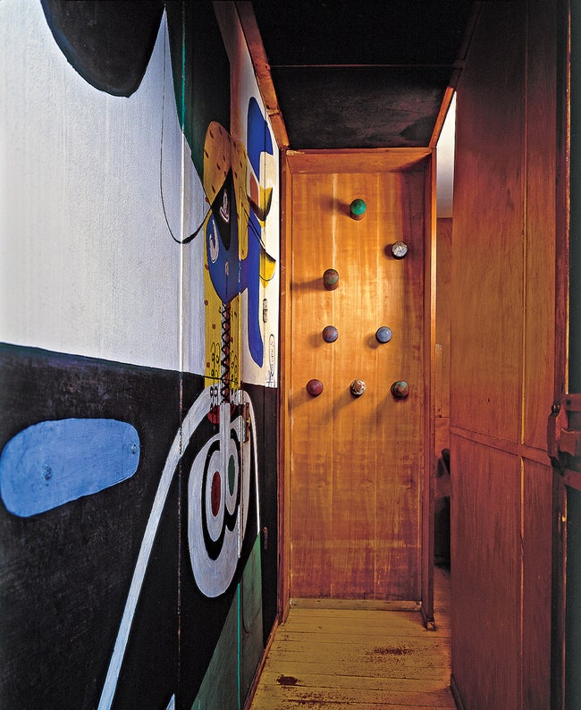 Платяной шкаф с забавными вешалками сделан в виде крошечной выгородки. На стене — живопись Ле Корбюзье.