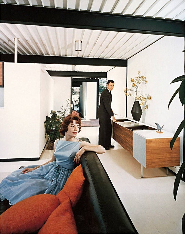 Фотография 1958 года Пьер Кёниг в гостиной Case Study House № 21. Архитектор запечатлен в компании неизвестной девушки....