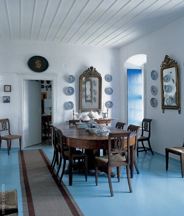 Парадная столовая. Антикварный овальный стол сделан из ореха. На стенах — греческие декоративные керамические тарелки.