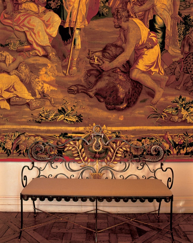 На стене в холле — гобелен XVII века. Диван из кованого металла дизайнер Жильбер Пуайера 1940е годы.