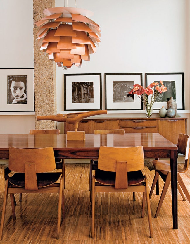 Обеденный стол сделанный по дизайну Финна Юля окружают стулья Робина Дея . Лампа Artichoke  Поуля Хеннингсена....