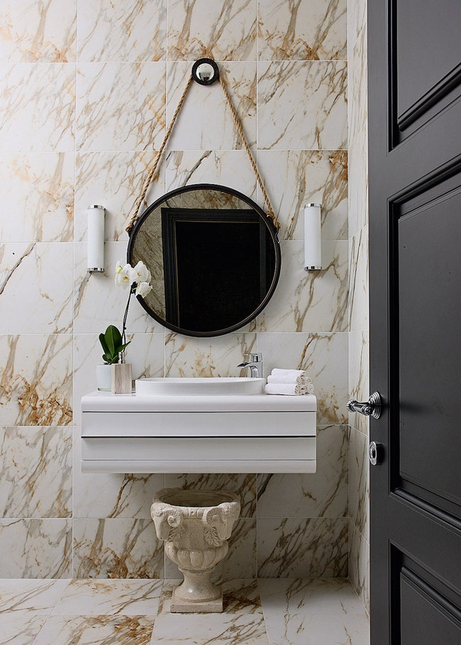 Стены и пол в ванной хозяев отделаны керамогранитом с узором имитирующим мрамор.