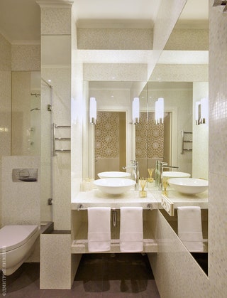 Стены ванной комнаты выложены плиткой имитирующей перламутровую мозаику она хорошо отражает свет.