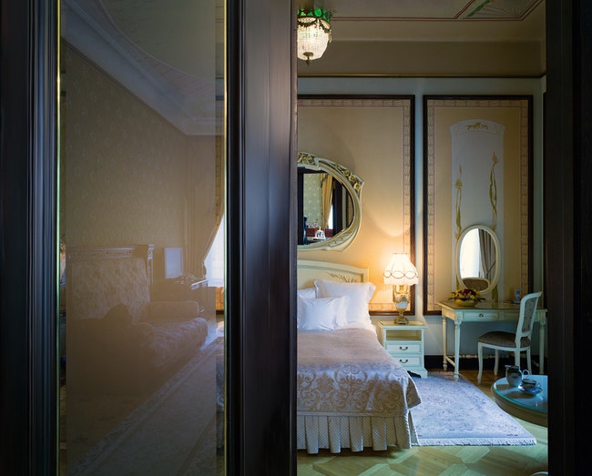 Спальня президентского люкса в отеле оформлена в стиле арнуво в обстановке использована антикварная мебель.