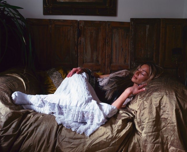 Хозяйка декоратор Сера ХершамЛофтус изображает Спящую красавицу. На диван накинута ткань из огромной коллекции текстиля Серы