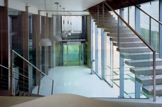 Вид на холл с площадки между этажами. Слева за стеклянной стеной — бассейн.