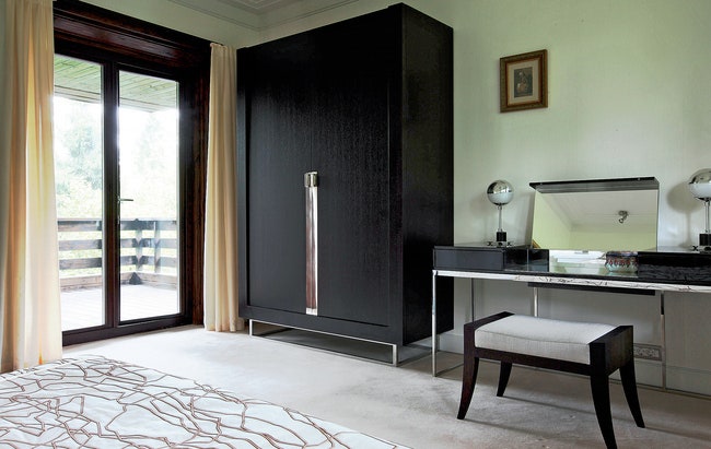 Платяной шкаф в спальне хозяев сделан по дизайну Олега Клодта в качестве дополнения к туалетному столику марки JNL....