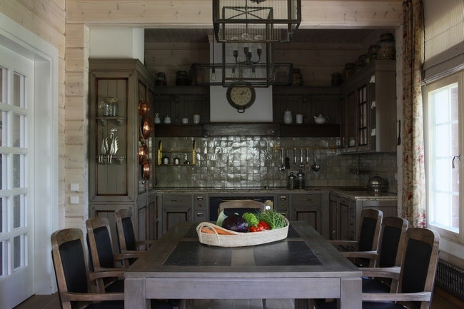 Кухонный фартук выложен плиткой ручной работы. Кухонная мебель из массива Arcari. Стулья и стол с каменной столешницей...