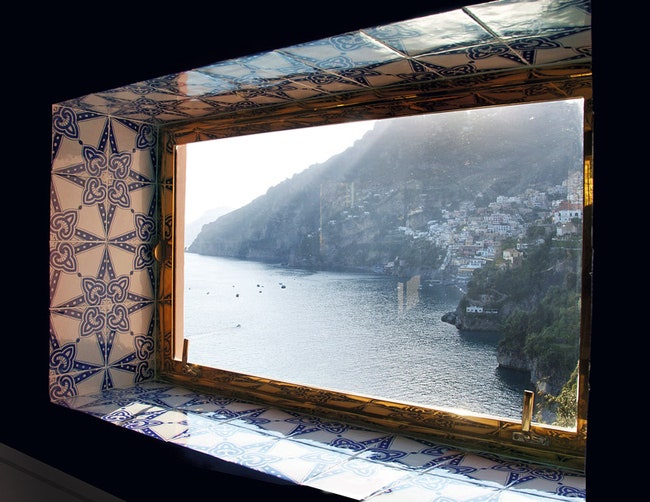 На широком подоконнике окна на Белой вилле можно сидеть наслаждаясь видами Позитано. Оконный проем отделан плиткой Вьетри.