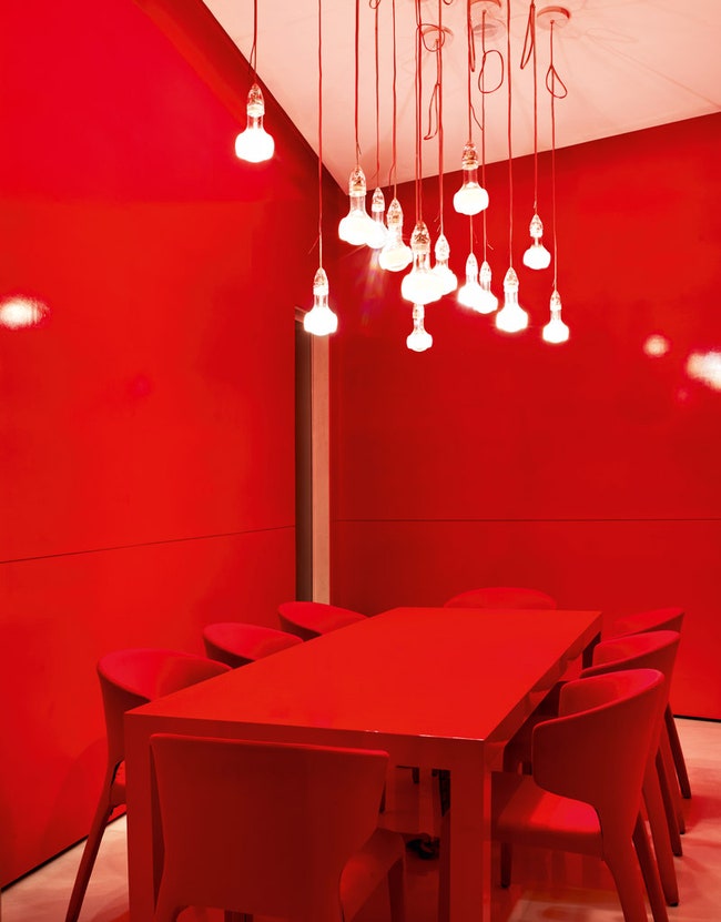 Красная переговорная в центре продаж. Стол сделан на заказ стулья Hola Cassina светильник Johnny B. Good Ingo Maurer.