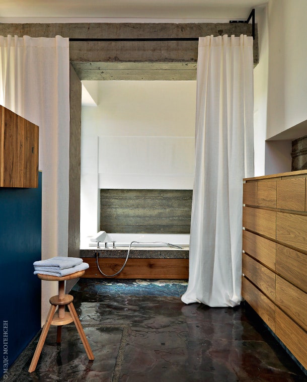 В приватной зоне цокольного этажа хозяйская спальня отделена от ванной с окном причудливым изголовьем кровати.