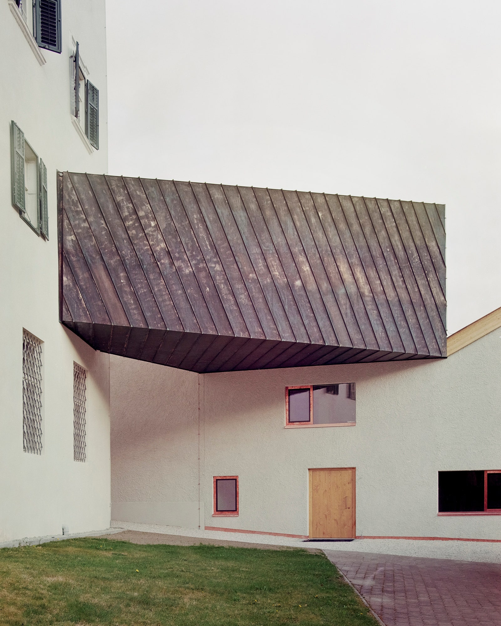 Галерея с металлической обшивкой соединяющая три строения с выставочными пространствами.